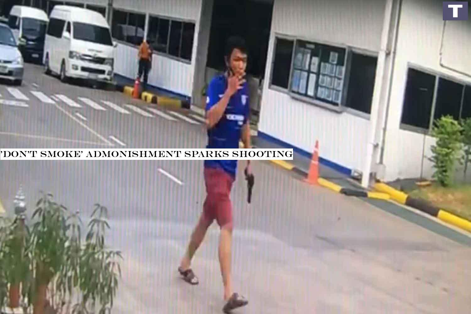 Suspect Thirawat Thamkhanthee, 27, gun in hand and smoking a cigarette, walks away from a factory in Samut Prakan province on Tuesday evening. He was later arrested for trying to kill a work colleague. (Photo supplied) 'Don't smoke' admonishment sparks shooting