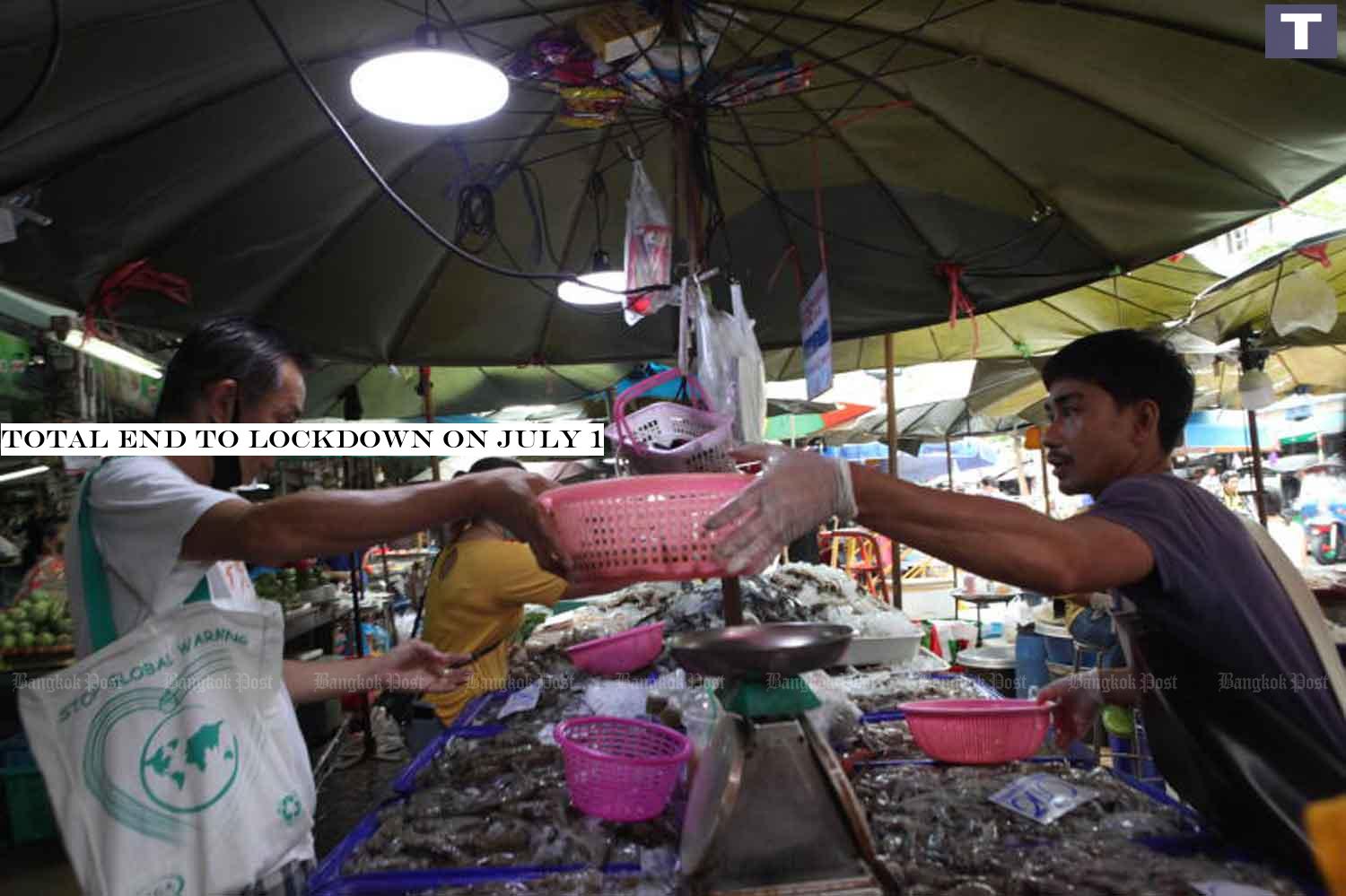 Some vendors and customers remove face masks at Wong Wian Yai market in Bangkok on Thursday even though the government is asking people to wear them. Security officials say all businesses and activities will be allowed to resume in July. (Photo by Arnun Chonmahatrakool) Complete end to lockdown on July 1