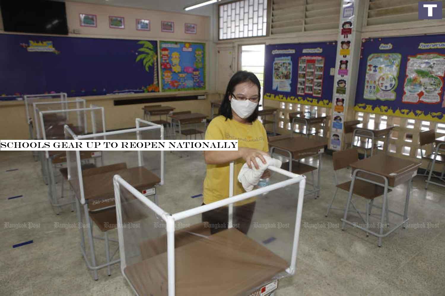 A member of staff at Or-ngern School in Bangkokâ-#128;-#153;s Sai Mai district cleans student cubicles. Plastic see-through partitions have been installed on tables in the cafeteria to keep students distanced from one another. (Photo: Nutthawat Wicheanbut) Schools gear up to reopen nationally