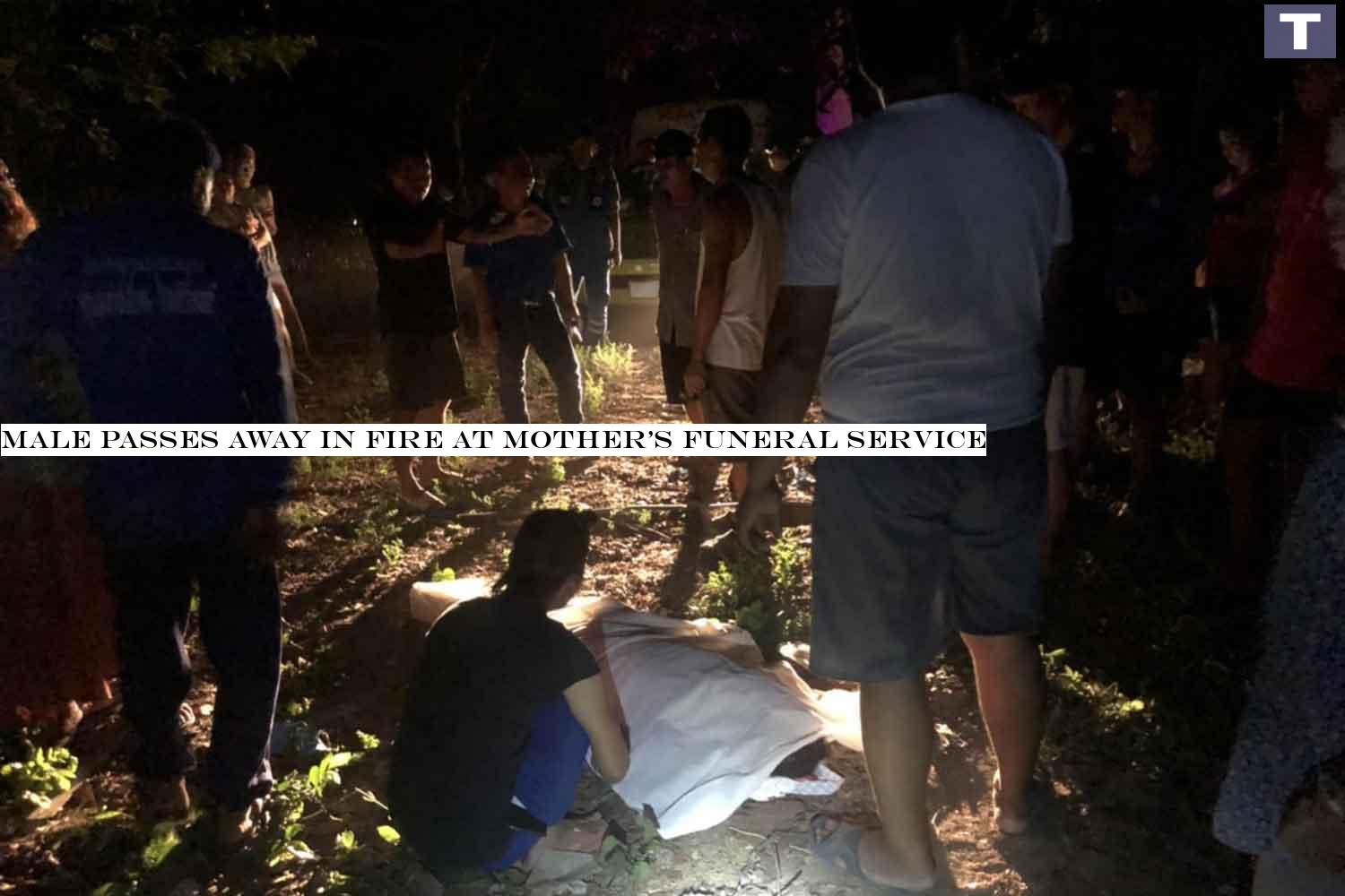The charred body of the dead man is covered with white cloth after being moved from the burned down hut, near the house where his mother's funeral rites were in progress, in Muang district of Kalasin province on Tuesday night. (Photo: Yongyuth Phuphuangpet) Man dies in fire at mother's funeral