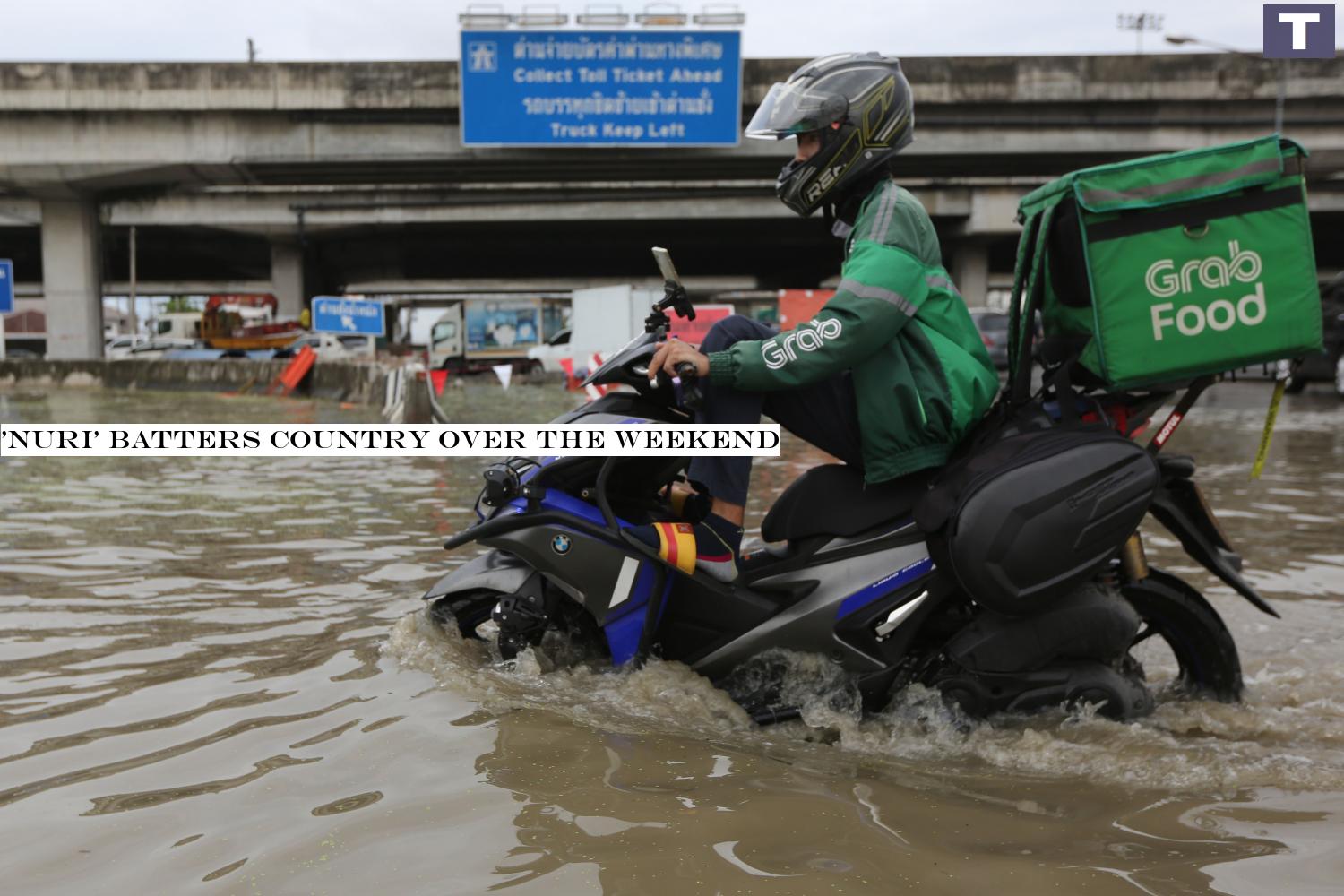 A Grab food delivery man rides his motorcycle through floodwaters on Srinakarin Road in the capital. Several streets in Bangkok were inundated after heavy downpours yesterday morning.â-#128;-#137;Wichan Charoenkiatpakul 'Nuri' batters country over the weekend