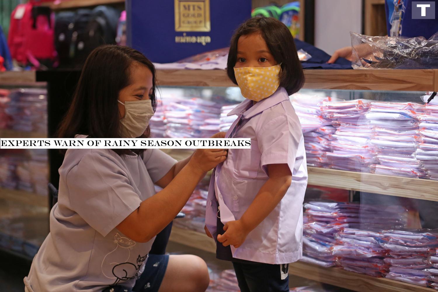 A mother helps her little girl try on a new school uniform at a store in Bang Kapi district of the capital. More parents are visiting shops to buy uniforms for their children ahead of the new school term which starts on July 1.â-#128;-#137;Varuth Hirunyatheb Experts warn of rainy season outbreaks