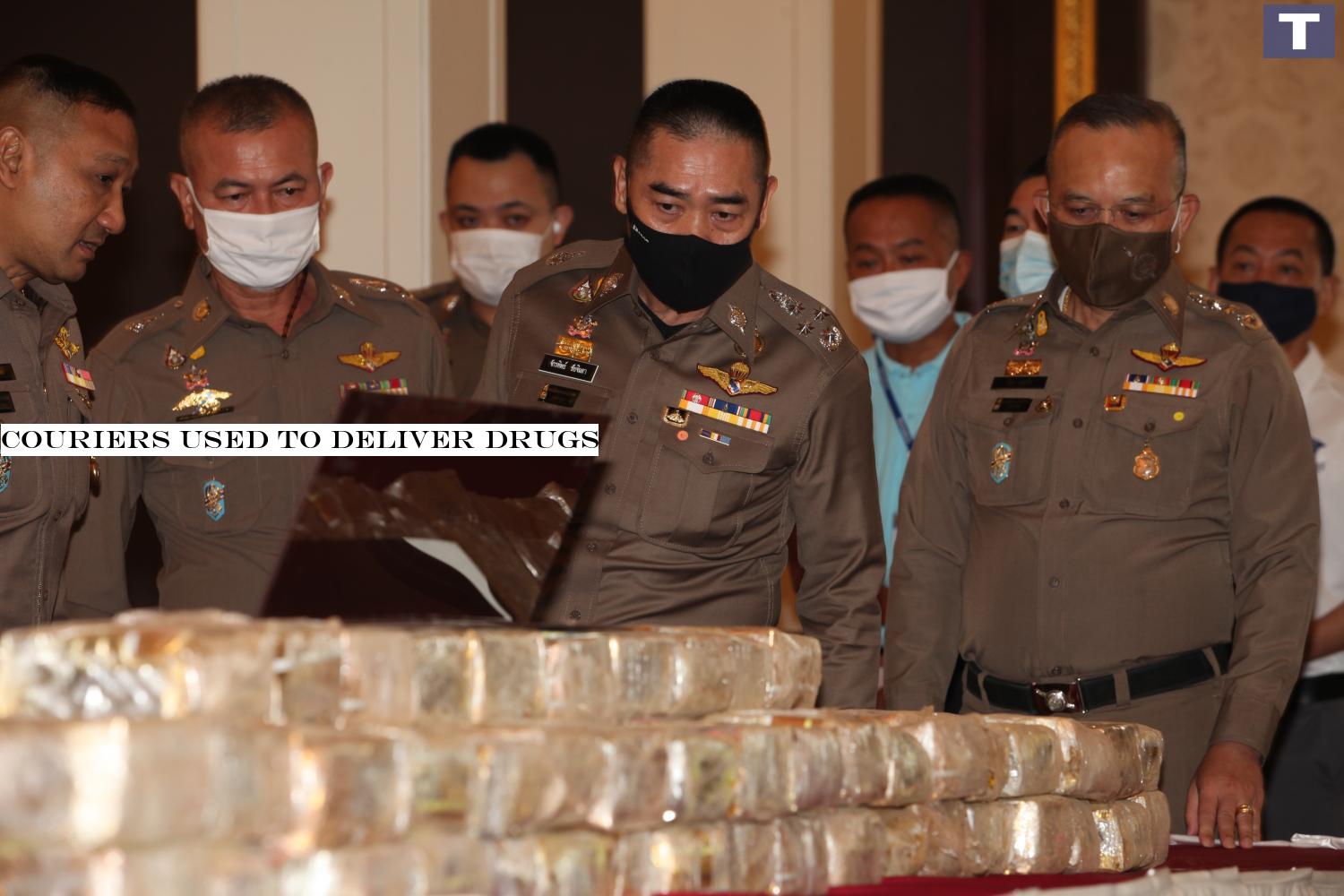 National police chief Pol Gen Chakthip Chaijinda, wearing a black face mask, looks at packs of crystal methamphetamine displayed at a press conference yesterday. The drugs were seized in a crackdown at a petrol station in Lop Buri province, in which three suspects were arrested.â-#128;-#137;(Photo by Apichart Jinakul) Couriers used to deliver drugs