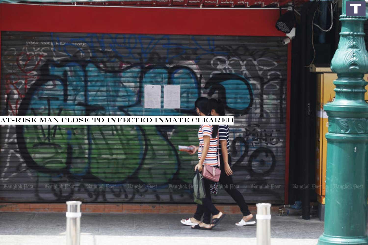 Two women walk past First Cafe on Khao San Road in Bangkok. The shop was temporarily closed after an inmate who used to work as a DJ at the shop was found to be infected with Covid-19. (Photo by Nutthawat Wicheanbut) At-risk man close to infected inmate cleared