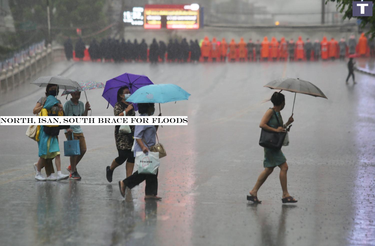 Pedestrians cross a street in heavy rain near Ratchaprasong intersection, which was sealed off by a huge security force yesterday evening. The rally location was moved to near Pathumwan intersection.â-#128;-#137;Apichit Jinakul North, Isan, South brace for floods