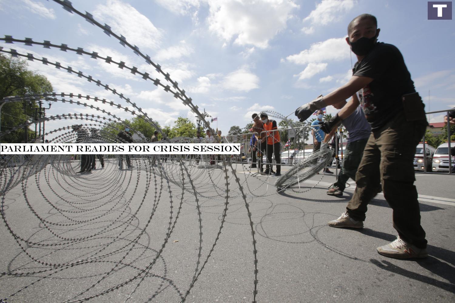 Barbed wire is laid on a road to form a barrier during an anti-protest drill conducted by security officers yesterday. The exercise was part of stepped-up security around Government House.â-#128;-#137;(Photo by Pornprom Sarttarpai) Parliament readies for crisis session
