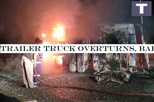 Firefighters extinguish the burning trailer truck that had overturned on a hill road in Nidi district of Prachin Buri province early no Wednesday. A two-month-old child travelling in the truck was killed. (Photo by Manit Sanubboon) Trailer truck overturns, baby killed