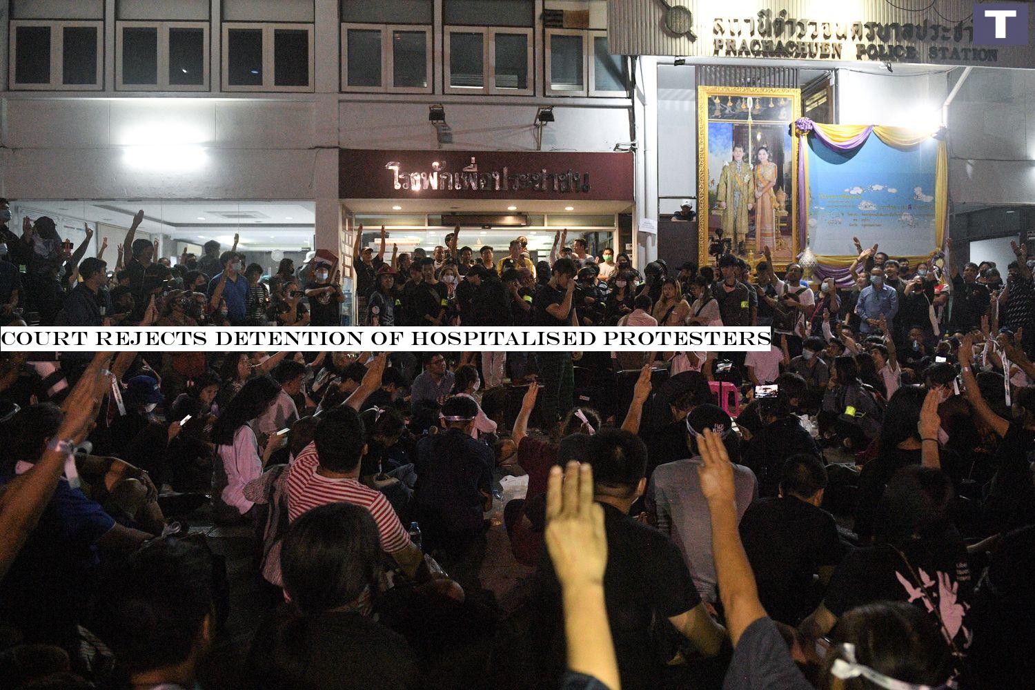 Demonstrators flash the three-finger salute as they gather outside the Pracha Chuen police station in Bangkok on Friday night. (Reuters photo) Court rejects detention of hospitalised protesters